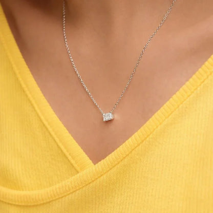 Emerald cut lab grown diamond pendant necklace on model in yellow top, Delux Jewelry