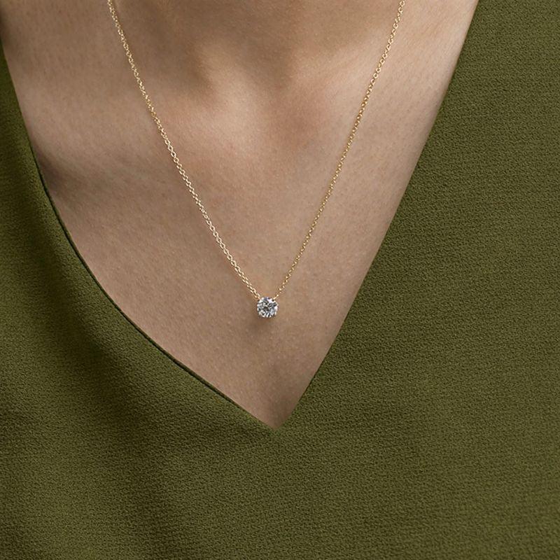 Woman wearing a gold lab grown diamond pendant necklace from Delux Jewelry
