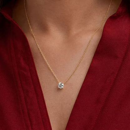 Gold chain necklace with round lab grown diamond pendant on woman in red top