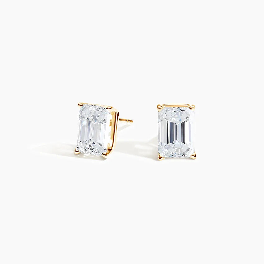 Emerald cut lab diamond stud earrings in 14K yellow gold from Delux Jewelry on white background
