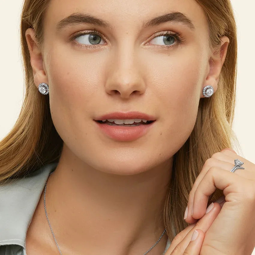 Woman wearing 2.5 CTW lab grown diamond halo stud earrings in 14K white gold by Delux Jewelry