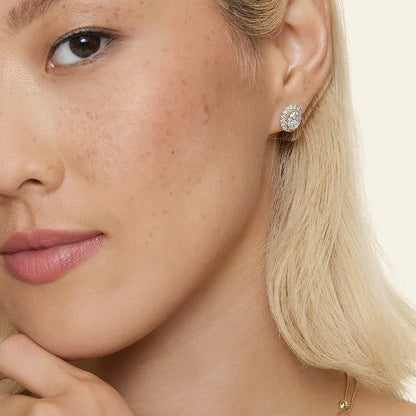 Woman wearing oval halo lab diamond stud earring in 14K yellow gold by Delux Jewelry