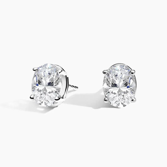 Oval lab grown diamond stud earrings in white gold by Delux Jewelry on white background